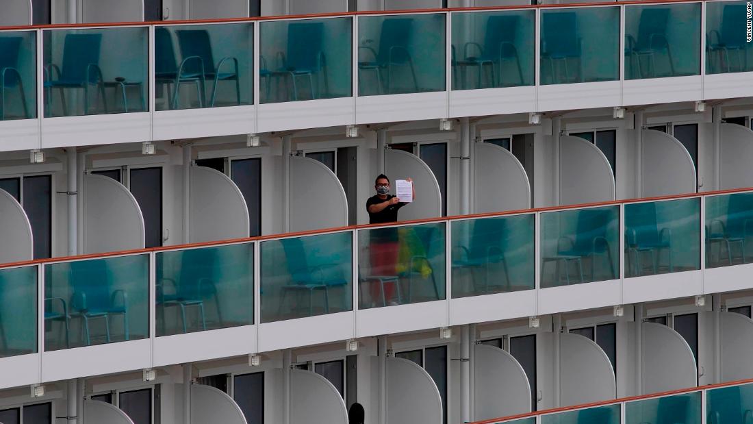 A passenger shows a note from the World Dream cruise ship docked at the Kai Tak cruise terminal in Hong Kong on February 5.